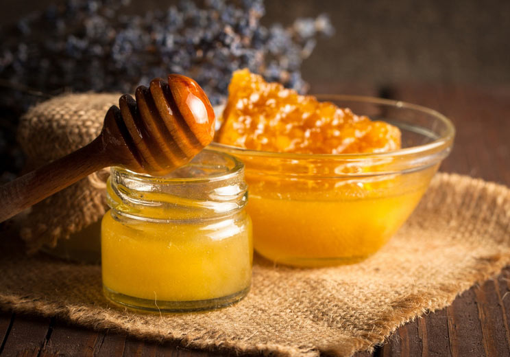 Honey-dripping-from-a-wooden-honey-dipper-in-a-jar.jpg