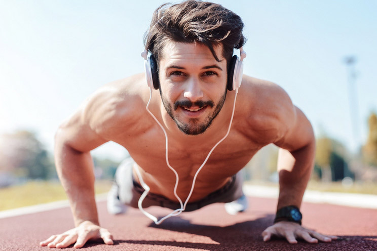 Sportsman-doing-push-ups-and-listening-to-music-with-headphones.jpg