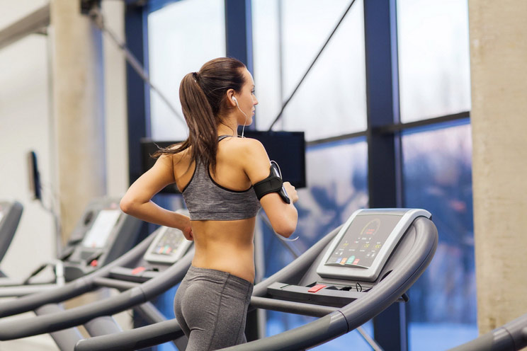 Woman-with-earphones-exercising-on-treadmill-in-gym.jpg